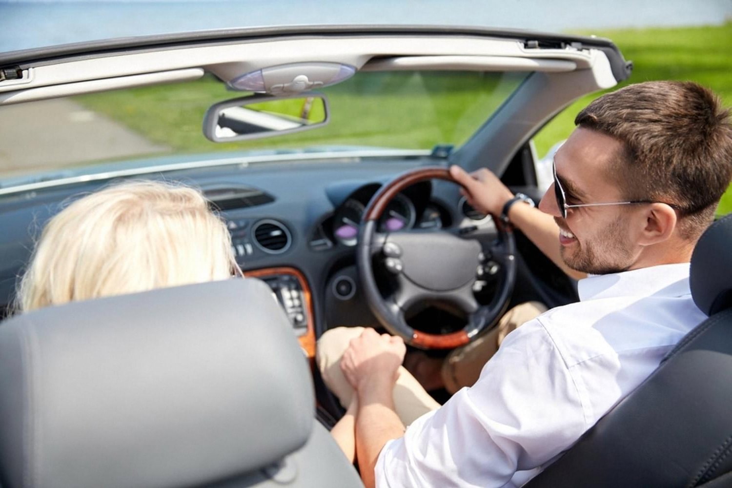 Couple driving a rental convertible along an Australian coastal road